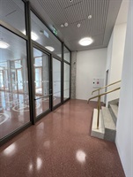Corridor with glazed walls and red terrazzo flooring