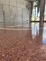 Detail of red terrazzo by a glazed wall