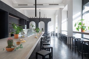 Kafkův dům café - bar with plants and dark terrazzo flooring