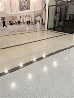 White terrazzo floor with a black stripe and light reflections
