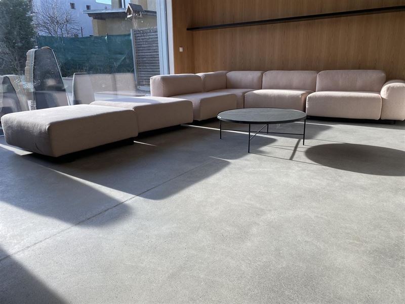 Betonboden in einer Lounge mit Sofa, Ausblick vom Fenster