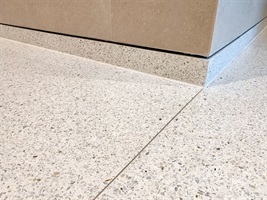 Heller Terrazzosockel mit Kante an einem Holzschrank in Rezidence Churchill