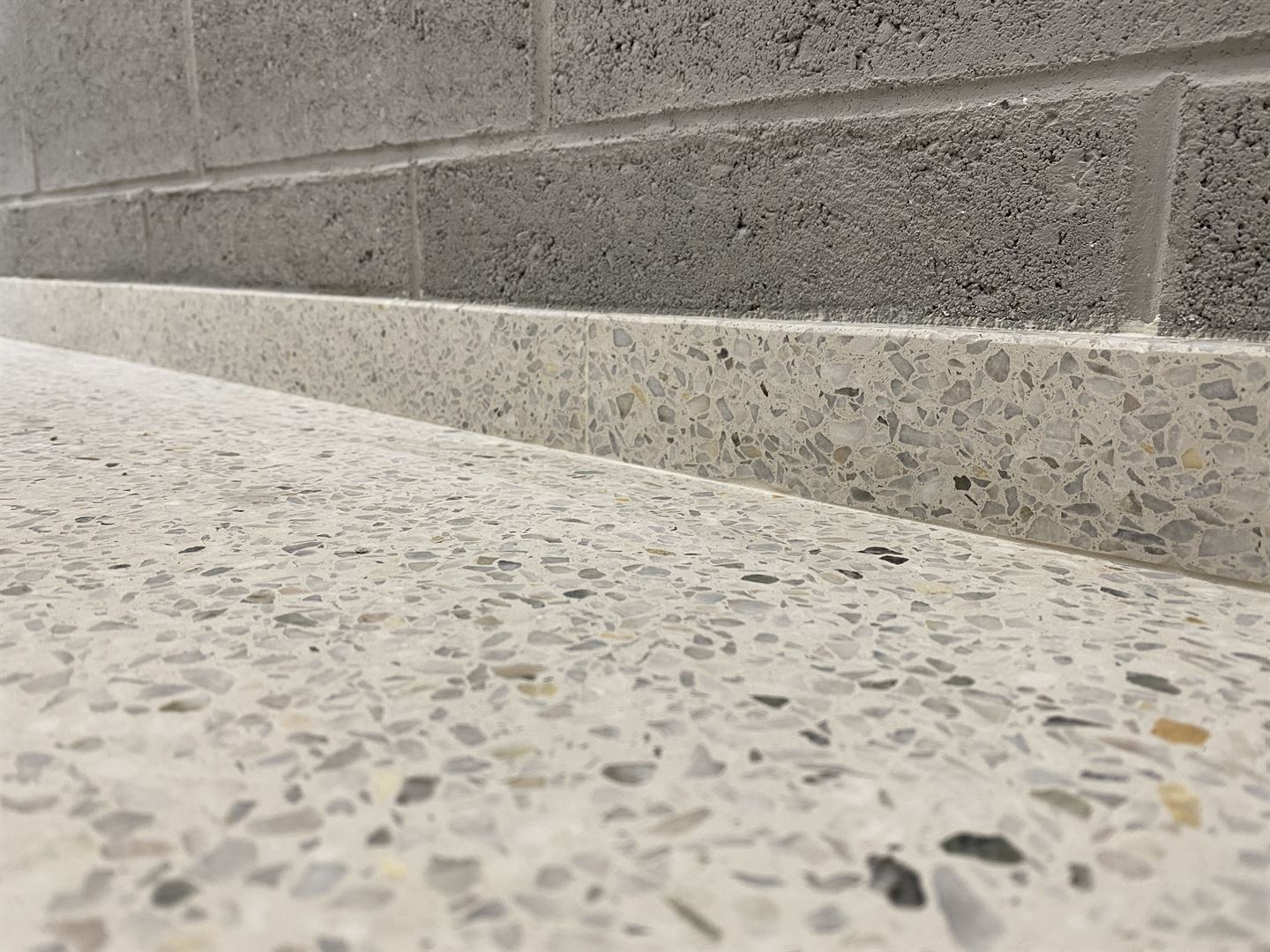 Terrazzosockel mit dunkler Kante an hellem Boden