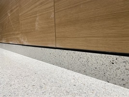 Terrazzosockel unter einer holzverkleideten Wand in Rezidence Churchill