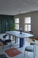 Esstisch mit blauer Vase und Stühlen an den Fenstern in der Wohnung Ovenecká