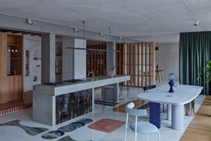 Küchen- und Essbereich der Wohnung Ovenecká mit Betoninsel und grünem Vorhang