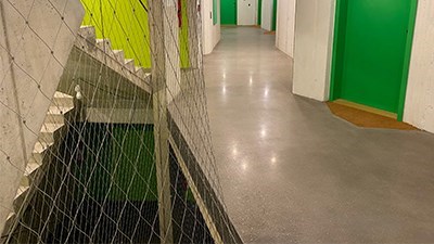 Hladká šedá podlaha v chodbě s barevnými dveřmi – podklad pod podlahu