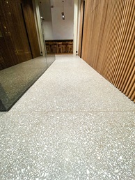 Chodba s dřevěným obkladem stěn a litou terrazzo podlahou