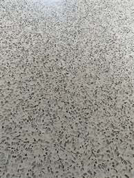 Detail šedé lité terrazzo podlahy s kamínky