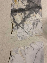 Vkládaný ornament ze šedozlatého mramoru ve světlé lité terrazzo podlaze