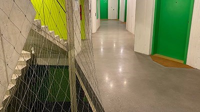 Betonové schodiště s ocelovou lanovou zábranou a zelenými stěnami