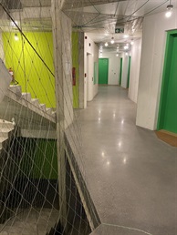 Chodba s leštěnou betonovou podlahou a barevnými dveřmi