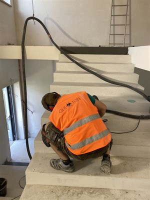 Pracovník při broušení lité teracové schodnice