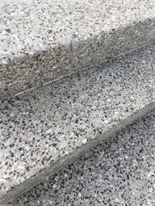 Detail hrany a povrchu teracového schodu s kamínky