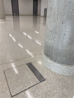 Sloup a podlahový revizní poklop v lité terrazzo podlaze